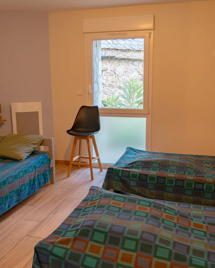 Une chambre du gîte de Malbouzon : lits une place, fenêtre donnant sur le village