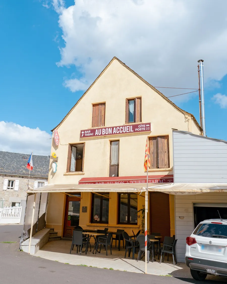 La terrasse d'Au Bon Accueil sous son auvent, tables et chaises installées devant le café
